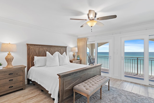 bedroom featuring light wood finished floors, access to exterior, a ceiling fan, a water view, and crown molding