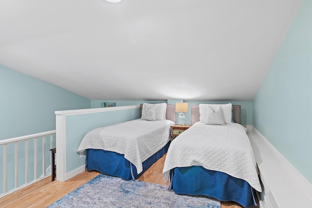 bedroom featuring lofted ceiling and wood finished floors