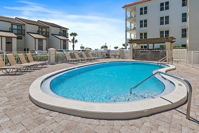 community pool featuring a pergola, a patio, and fence