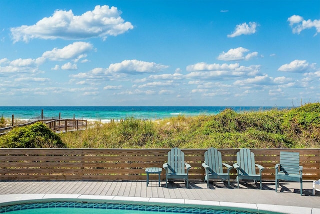 view of swimming pool with a view of the beach and a deck with water view