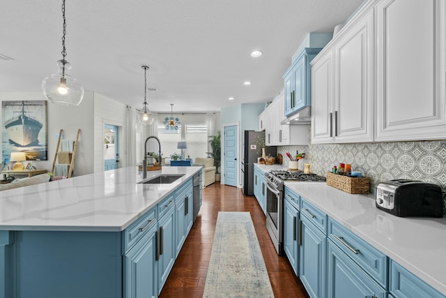 kitchen featuring tasteful backsplash, a sink, blue cabinets, stainless steel appliances, and white cabinetry