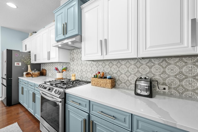 kitchen featuring blue cabinets, under cabinet range hood, stainless steel appliances, and light countertops