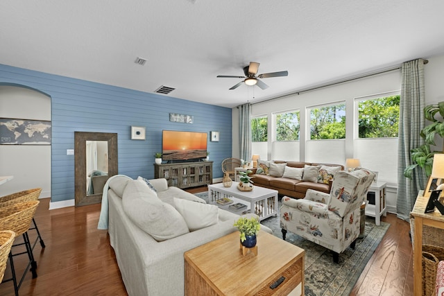 living area with wood finished floors, visible vents, and ceiling fan