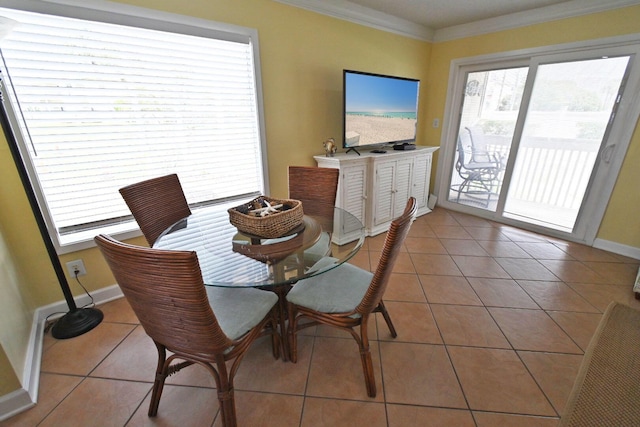 tiled dining area with crown molding, baseboards, and plenty of natural light