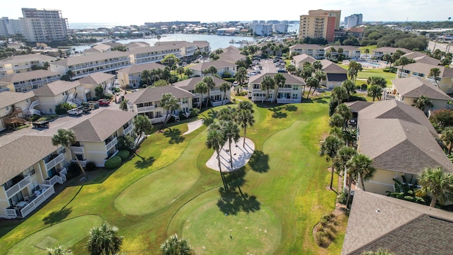 drone / aerial view with golf course view and a water view