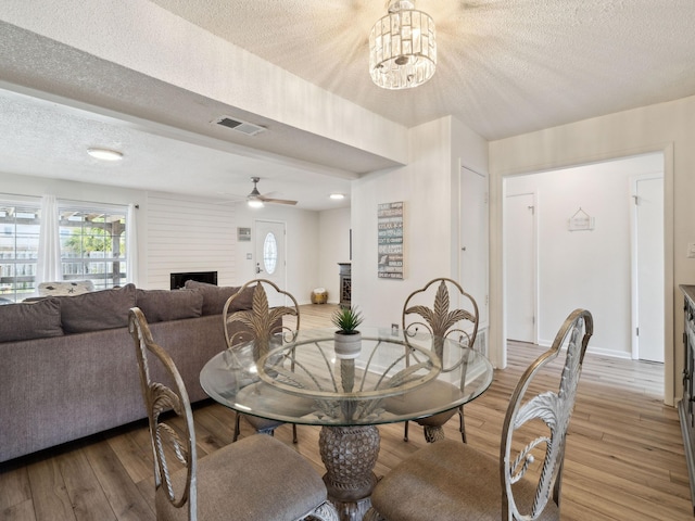 356 Billfish Ave Unit 4, Fort Walton Beach, FL 32548 - dining space featuring a fireplace, a textured ceiling, light wood-type flooring, and visible vents