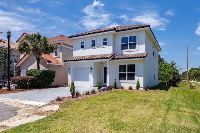 mediterranean / spanish home featuring an attached garage, a tile roof, a front yard, and decorative driveway
