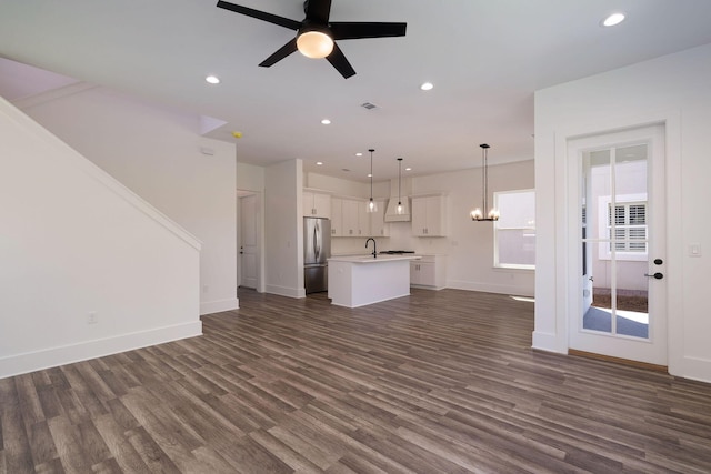 unfurnished living room with baseboards, dark wood-type flooring, and recessed lighting