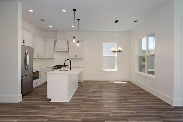 kitchen with recessed lighting, dark wood finished floors, a sink, premium range hood, and freestanding refrigerator