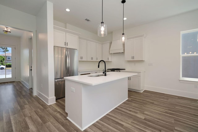 kitchen with white cabinets, freestanding refrigerator, a sink, and dark wood-style floors