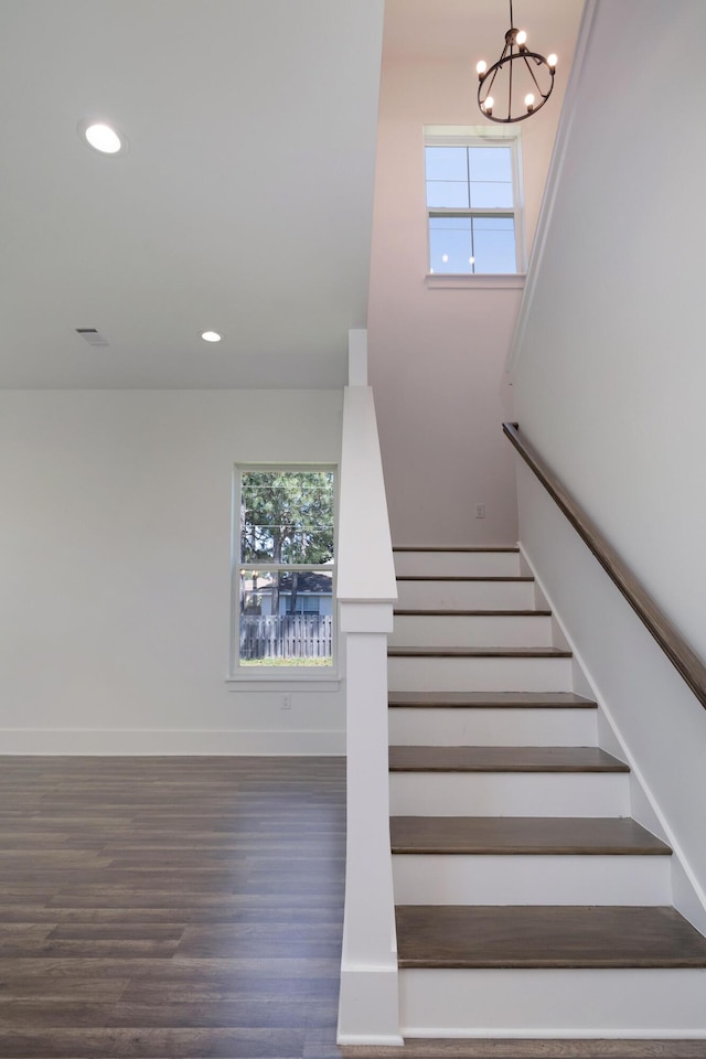 stairs with a chandelier, a healthy amount of sunlight, and recessed lighting