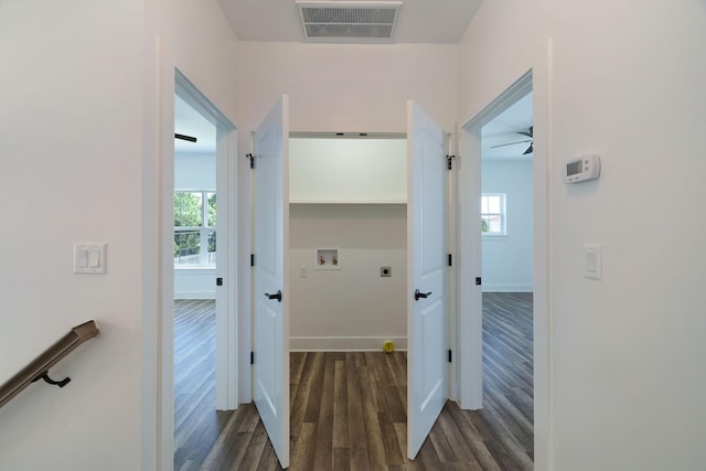 hall featuring wood finished floors, visible vents, and baseboards