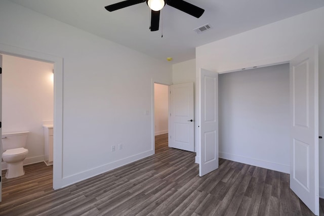 unfurnished bedroom with baseboards, dark wood-style flooring, ensuite bathroom, and visible vents