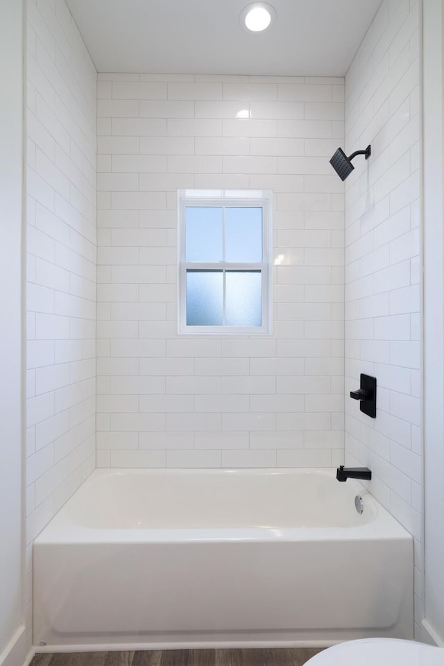 bathroom with bathing tub / shower combination and toilet