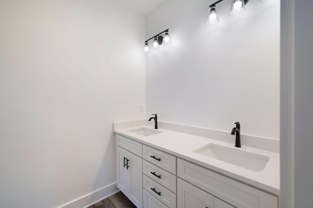 bathroom featuring wood finished floors, a sink, and double vanity