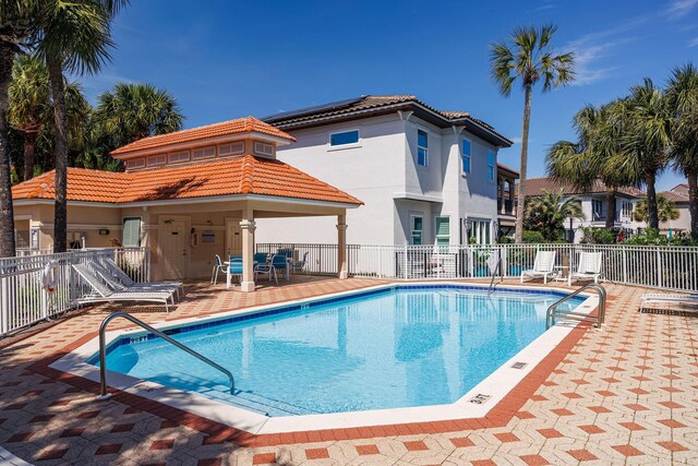 community pool with fence and a patio