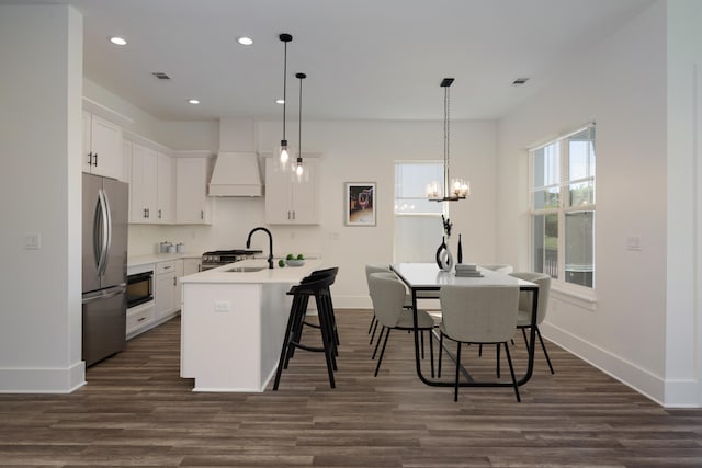 kitchen featuring a sink, freestanding refrigerator, premium range hood, dark wood finished floors, and recessed lighting