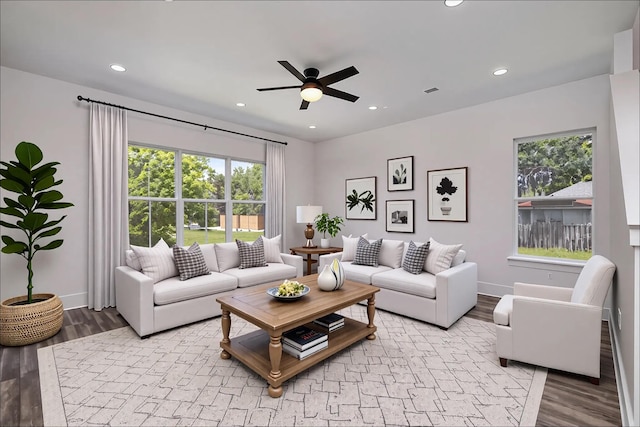 living room featuring baseboards, recessed lighting, a ceiling fan, and light wood finished floors