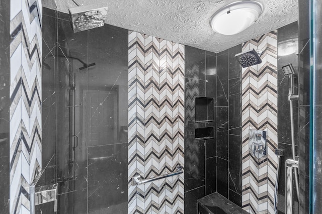 full bath with a shower stall and a textured ceiling