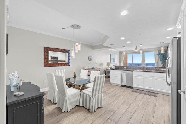 dining room with baseboards, ornamental molding, light wood finished floors, and recessed lighting