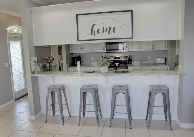 38 Aquamarine Cv, Miramar Beach, FL 32550 - kitchen with a peninsula, crown molding, stainless steel appliances, and a wealth of natural light