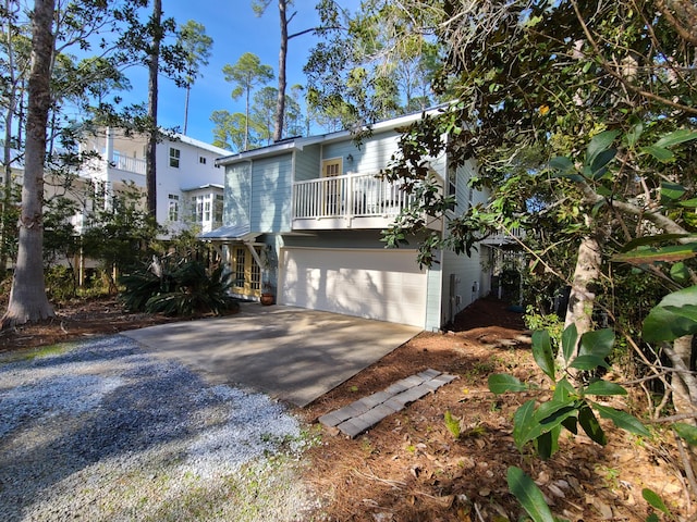 view of front of home featuring a garage, a balcony, and driveway