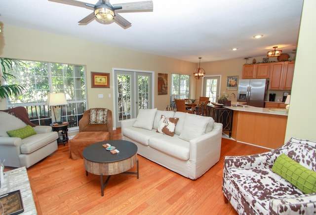 living area featuring light wood-style floors, ceiling fan, and recessed lighting