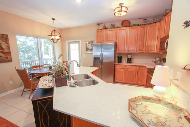 kitchen with light countertops, a chandelier, appliances with stainless steel finishes, and a sink