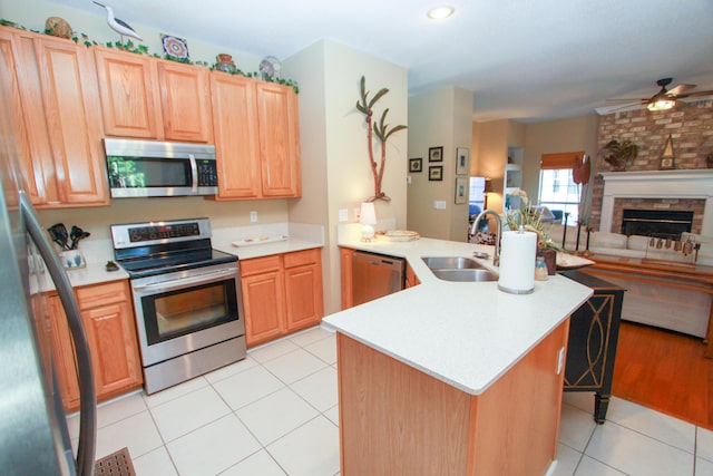 kitchen with ceiling fan, appliances with stainless steel finishes, a sink, a peninsula, and open floor plan