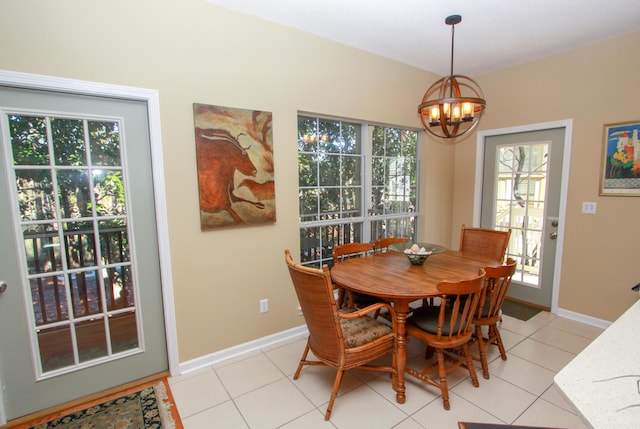 dining area with an inviting chandelier, baseboards, and light tile patterned floors