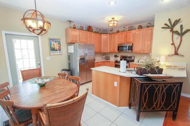 kitchen with an inviting chandelier, a peninsula, recessed lighting, light countertops, and stainless steel appliances