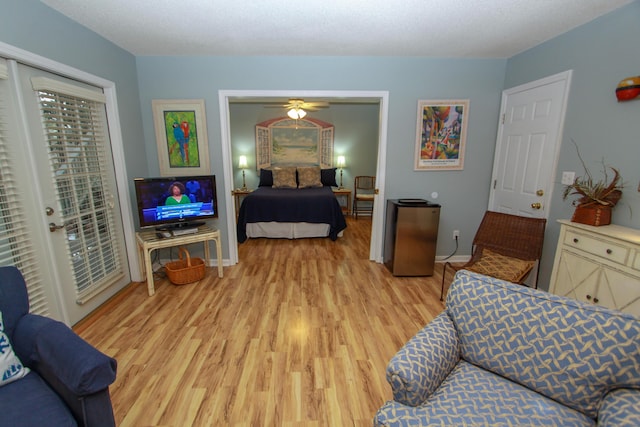bedroom with light wood-style floors, baseboards, and access to exterior