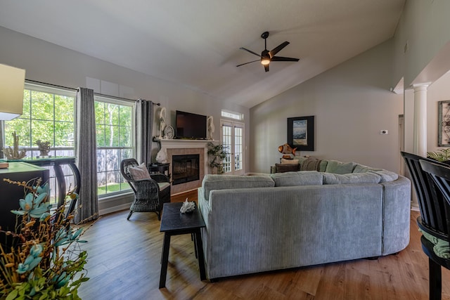 living area with lofted ceiling, a ceiling fan, wood finished floors, and a tile fireplace