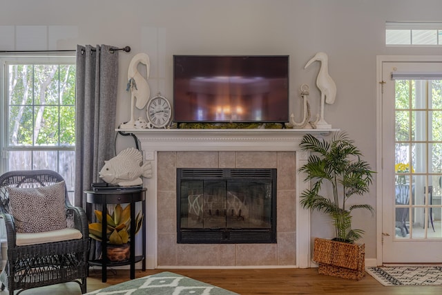 details with wood finished floors and a tiled fireplace