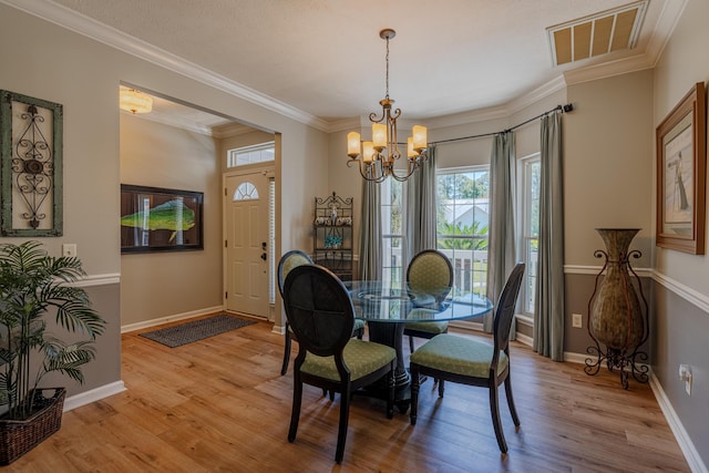 dining space with baseboards, a notable chandelier, crown molding, and light wood-style flooring
