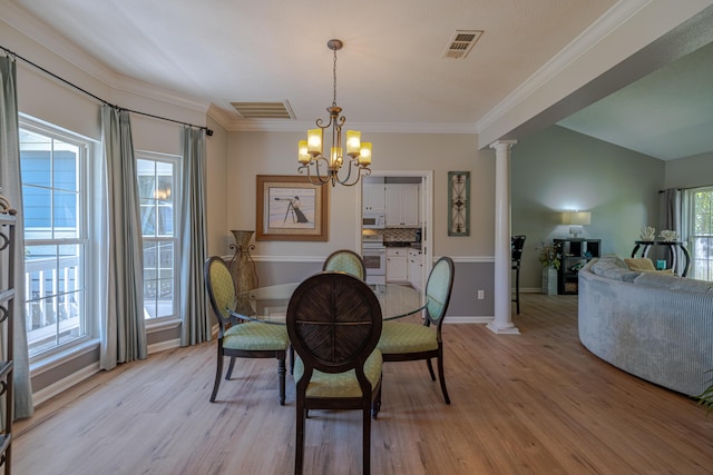 dining room featuring decorative columns, visible vents, light wood-style floors, and ornamental molding