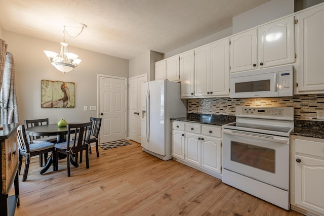 kitchen featuring white appliances, light wood-type flooring, decorative backsplash, a chandelier, and white cabinetry