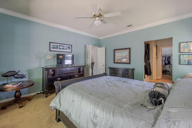 bedroom with crown molding, a spacious closet, carpet, baseboards, and visible vents