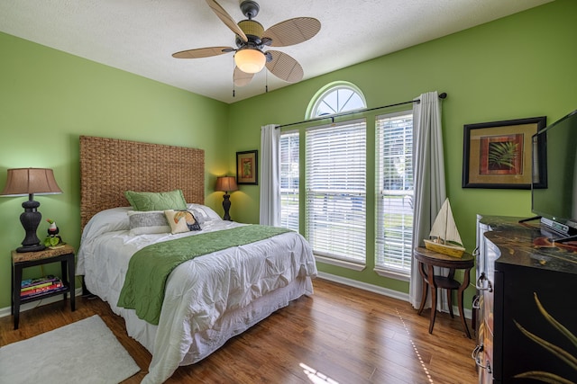 bedroom featuring baseboards, a ceiling fan, and wood finished floors
