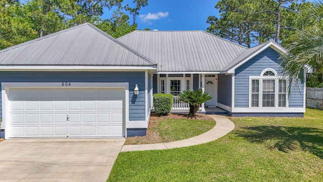 ranch-style home with a front lawn, driveway, a porch, metal roof, and an attached garage