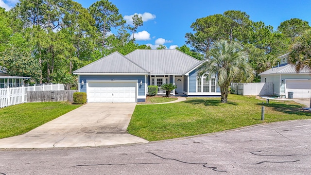 ranch-style home featuring metal roof, fence, a front lawn, concrete driveway, and a garage