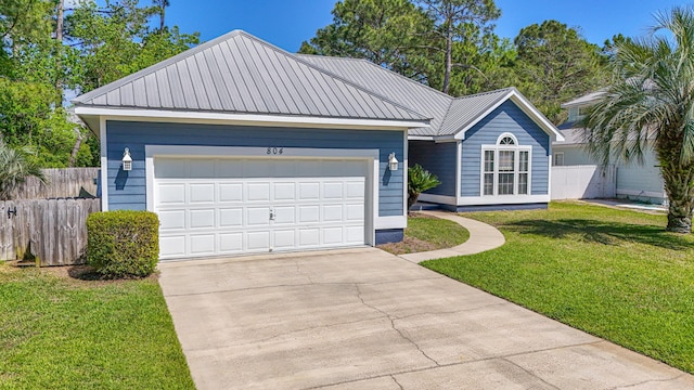 single story home with driveway, an attached garage, fence, a front yard, and metal roof