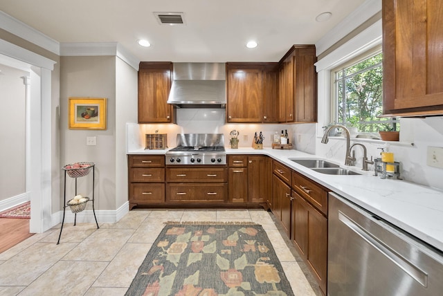 kitchen featuring stainless steel appliances, a sink, wall chimney range hood, visible vents, and crown molding