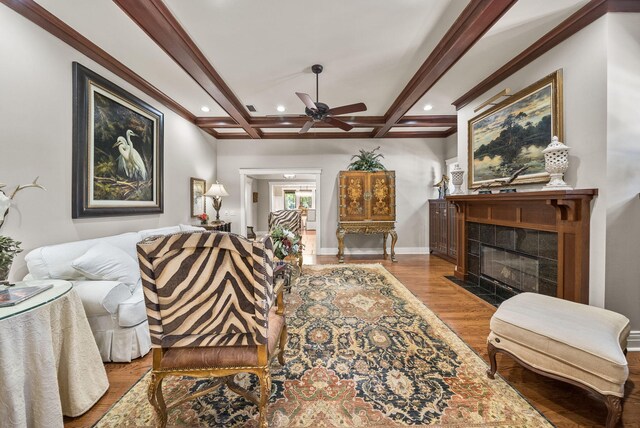 living room featuring a ceiling fan, wood finished floors, a tile fireplace, beamed ceiling, and recessed lighting