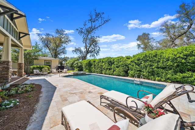 view of pool with a patio area and a pool with connected hot tub