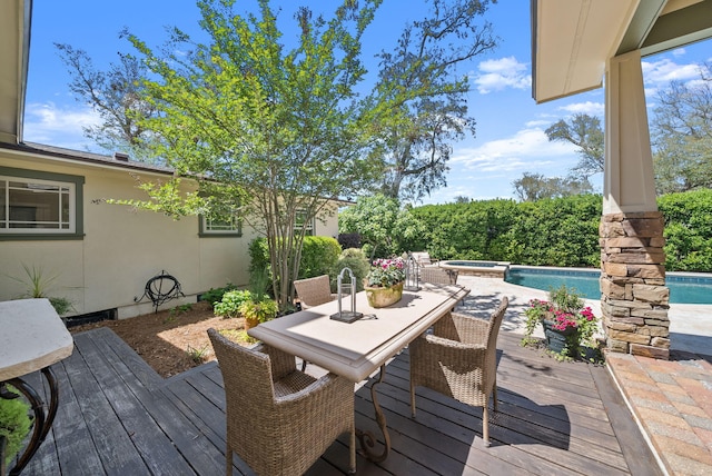 deck with a pool with connected hot tub and outdoor dining area