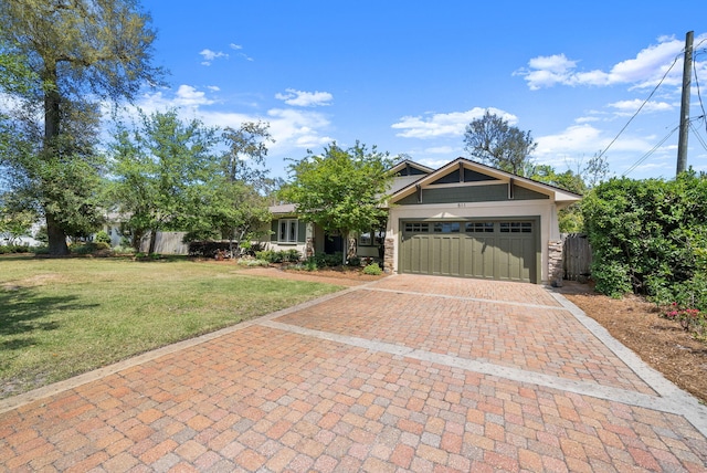 view of front facade with stone siding, an attached garage, a front yard, and decorative driveway