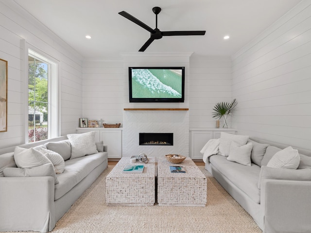 105 Greenbriar Ln, Santa Rosa Beach, FL 32459 - living area featuring a warm lit fireplace, wood walls, ornamental molding, ceiling fan, and light wood finished floors