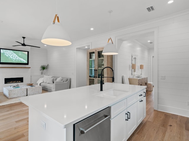 105 Greenbriar Ln, Santa Rosa Beach, FL 32459 - kitchen with stainless steel dishwasher, wood walls, light wood finished floors, a sink, and visible vents