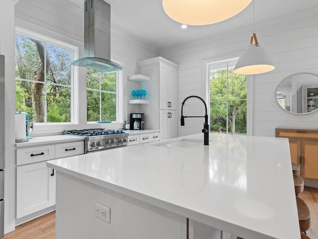 105 Greenbriar Ln, Santa Rosa Beach, FL 32459 - kitchen with stove, island range hood, light wood-style flooring, light countertops, and a sink